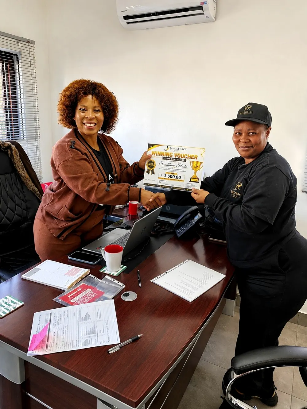 A Java Legacy consultant handing over a benefit voucher to a member